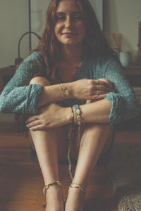 Portrait of a smiling young woman sitting at home