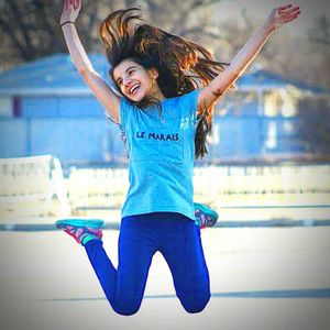 Portrait of young woman jumping outdoors