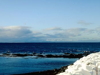 Scenic view of sea against blue sky