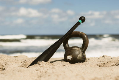 Close-up of chain on beach against sky