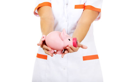 Low angle view of child holding camera over white background