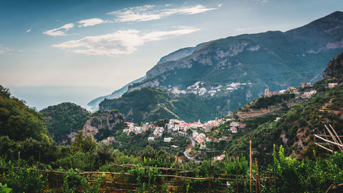 Scenic view of townscape by mountains against sky