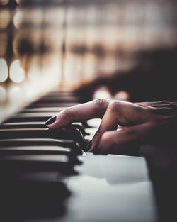 Cropped hand of woman playing piano