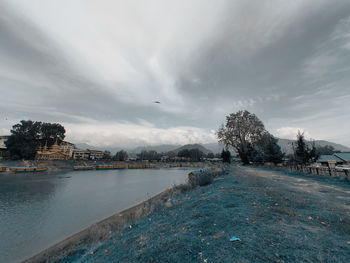 Scenic view of river by buildings against sky