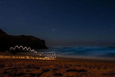 Scenic view of beach against sky at night