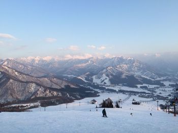 Person on snowcapped mountain against sky