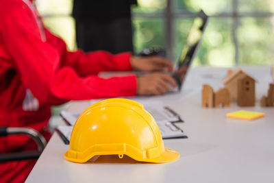 Midsection of woman holding red toy on table