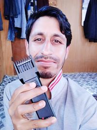 Portrait of young man holding camera