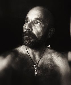 Portrait of shirtless man against black background