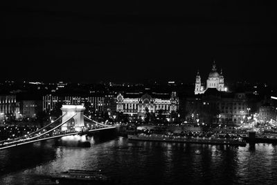 Illuminated bridge over river at night