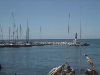 Sailboats in sea against clear sky