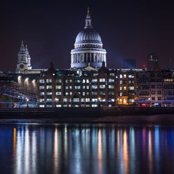 Reflection of illuminated government building in city at night