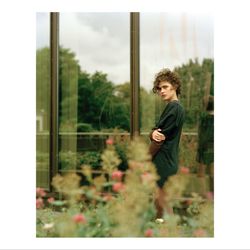 Side view of young man looking through window