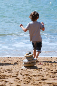 Rear view of boy walking on beach