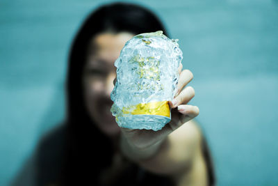  a can of beer coated by the ice held by the defocused woman in background. celebration with beer
