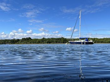 Sailboat sailing in sea against sky