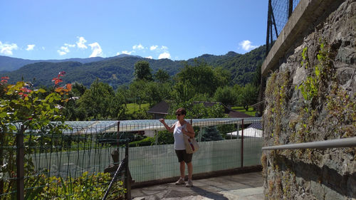 Man standing by railing against mountains