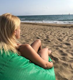 Midsection of woman sitting on beach