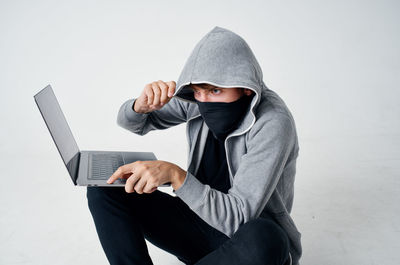 Young man using laptop while sitting on table