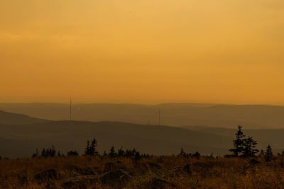 Scenic view of landscape against orange sky