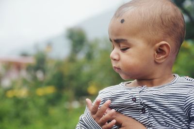 Close-up of cute boy looking away outdoors