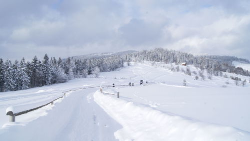 Panoramic view of snow covered land against sky