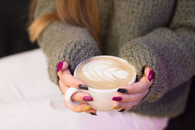 Midsection of woman holding coffee cup