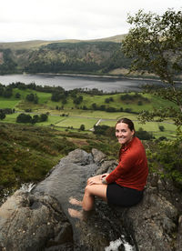 Portrait of woman sitting on rock