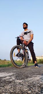 A indian boy with his bycycle on road and giving a perfect look 