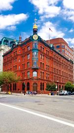 Road by buildings in town against sky