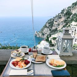 Breakfast served on table at restaurant with sea in background