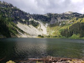 Scenic view of lake by mountains against sky