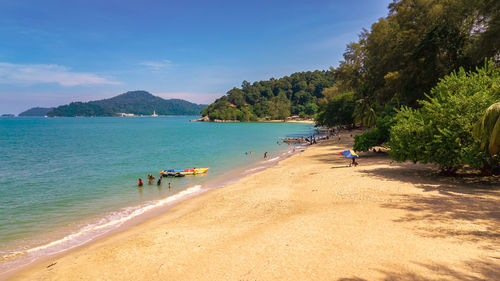 People on beach against sky