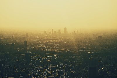 Aerial view of buildings in city against sky during foggy weather