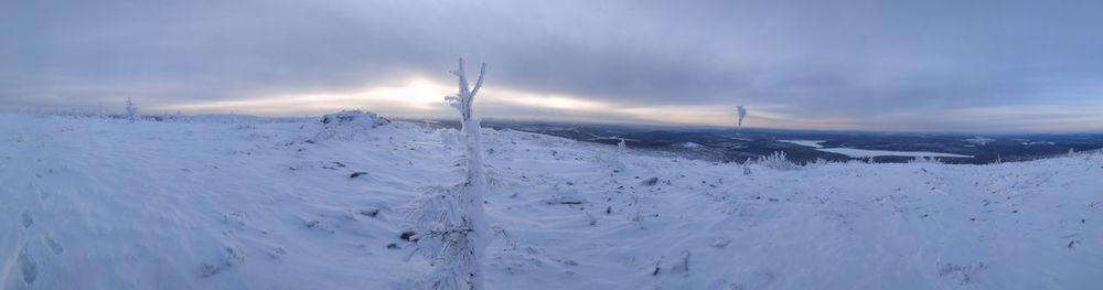 Scenic view of snow covered land against sky