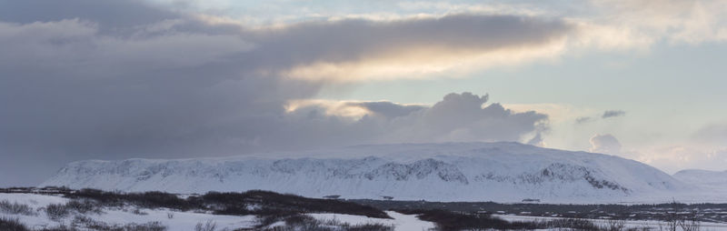 Scenic view of snow covered mountains against sky