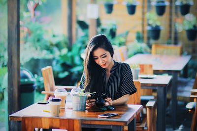 Woman looking away while sitting on table at cafe