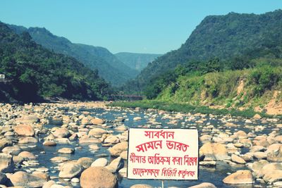 Information sign on mountain against sky