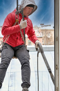 Low angle view of man working against sky