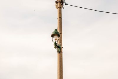 Low angle view of pole on wooden post against sky