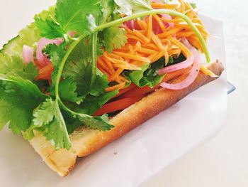 Close-up of sandwich served on tissue paper in plate