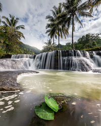 Scenic view of waterfall against sky