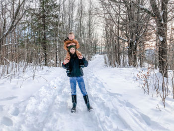 Full length of boy standing on snow covered field