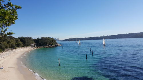 Calm sea against clear blue sky