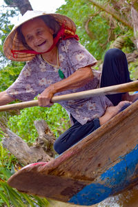 Rear view of a smiling girl holding plant