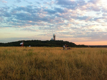 Scenic view of grassy field against cloudy sky