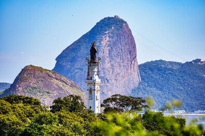 Panoramic view of buildings and mountains against blue sky