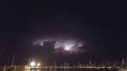 Low angle view of illuminated city against sky at night