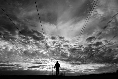 Rear view of silhouette man standing against sky