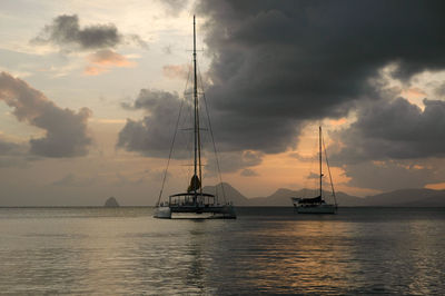 Sailboat sailing on sea against sky during sunset